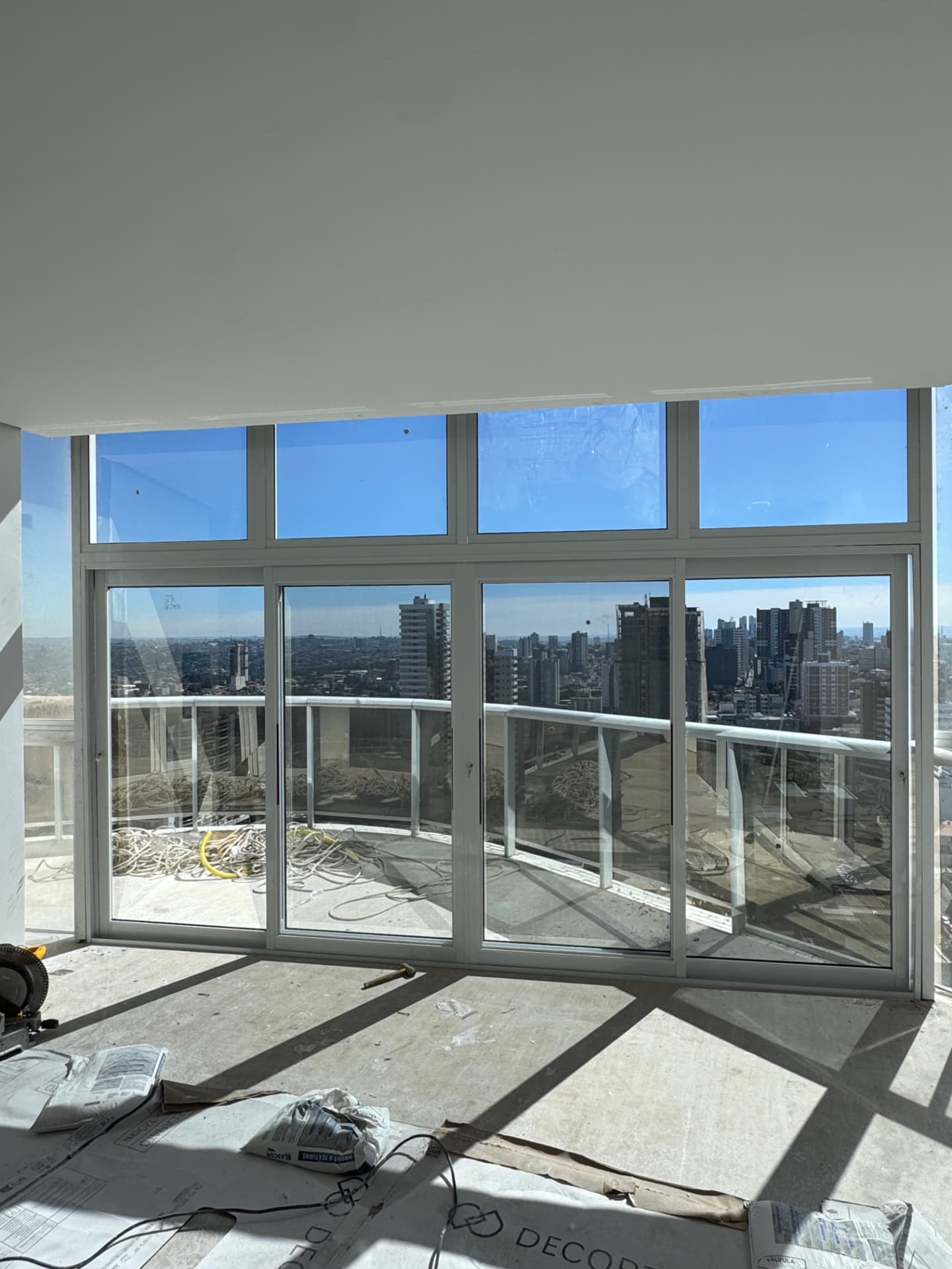 Esquadria de alumínio branca em grande vão com vista urbana